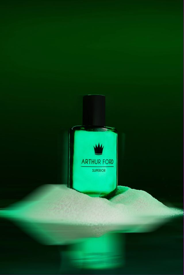 Green bottle glowing on white sand in green light